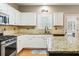 Well-lit kitchen featuring granite countertops, stainless steel appliances, and a tile backsplash at 1975 Fairway Close Ter, Lawrenceville, GA 30043