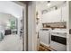 Well-lit laundry room with washer, dryer, storage cabinets, and access to the bedroom at 1975 Fairway Close Ter, Lawrenceville, GA 30043