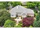 Aerial view of a brick house featuring a patio and well-manicured landscaping, surrounded by mature trees at 2117 Stephens Walk, Dunwoody, GA 30338