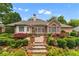 Beautifully landscaped backyard with a stone patio, lush greenery, and a charming brick house at 2117 Stephens Walk, Dunwoody, GA 30338