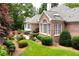 View of a beautiful red brick home with manicured backyard featuring a stone patio and lush landscaping at 2117 Stephens Walk, Dunwoody, GA 30338