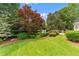 Expansive backyard featuring a manicured lawn, lush greenery, and a charming garden bench at 2117 Stephens Walk, Dunwoody, GA 30338