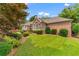 Charming brick home with a well-manicured lawn, lush greenery, and mature trees at 2117 Stephens Walk, Dunwoody, GA 30338