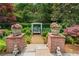 Charming garden bench surrounded by brick pillars, flowers, lush foliage, and a stone path at 2117 Stephens Walk, Dunwoody, GA 30338
