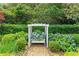Secluded garden bench surrounded by lush greenery, hydrangea, and a stone path at 2117 Stephens Walk, Dunwoody, GA 30338