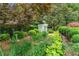 Lush, landscaped yard with a stone path leading to a garden bench and vibrant plants at 2117 Stephens Walk, Dunwoody, GA 30338