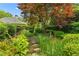 Lush, landscaped yard with vibrant plants, stone path, and a manicured lawn at 2117 Stephens Walk, Dunwoody, GA 30338