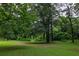 Expansive backyard featuring mature trees and a lush lawn, creating a private and serene outdoor space at 380 Lamplighter Se Ln, Marietta, GA 30067