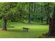 Lush backyard featuring mature trees, manicured lawn, and a peaceful bench to enjoy the serene surroundings at 380 Lamplighter Se Ln, Marietta, GA 30067