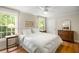 Bright bedroom features hardwood floors, a ceiling fan, and large windows with a view of mature trees at 380 Lamplighter Se Ln, Marietta, GA 30067