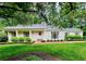 Charming single-story home featuring a manicured lawn, brick walkway, and lush landscaping at 380 Lamplighter Se Ln, Marietta, GA 30067