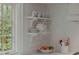 Close up of kitchen's open shelving with fruit and dinnerware alongside large window at 380 Lamplighter Se Ln, Marietta, GA 30067