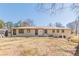 A rear view of a charming ranch-style home with a spacious backyard and a small outdoor seating area at 442 Mountain Park Trl, Stone Mountain, GA 30087