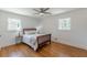 Cozy bedroom features hardwood floors, ceiling fan, and windows providing natural light at 442 Mountain Park Trl, Stone Mountain, GA 30087