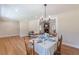 Bright dining room features hardwood floors, modern chandelier, and adjacent living room with fireplace at 442 Mountain Park Trl, Stone Mountain, GA 30087