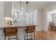 Kitchen island with granite countertop and bar seating, complemented by white cabinets and hardwood floors at 442 Mountain Park Trl, Stone Mountain, GA 30087