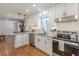 Modern kitchen featuring white cabinetry, granite countertops, stainless steel appliances, and hardwood flooring at 442 Mountain Park Trl, Stone Mountain, GA 30087