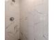 Close-up of a modern shower with marble-look tiles and contemporary fixtures at 442 Mountain Park Trl, Stone Mountain, GA 30087