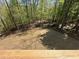 A sloped backyard has newly laid topsoil adjacent to a peaceful tree line, awaiting your personalization at 66 Pine Creek Ct, Dallas, GA 30157