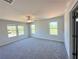Bright, spacious bedroom features plush carpeting, ceiling fan, and multiple windows offering backyard views at 66 Pine Creek Ct, Dallas, GA 30157