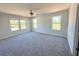 Sunlit spacious bedroom features plush carpeting, ceiling fan, and multiple windows offering backyard views at 66 Pine Creek Ct, Dallas, GA 30157