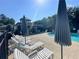 Community pool with ample lounge chairs, shady umbrellas and clubhouse at 66 Pine Creek Ct, Dallas, GA 30157