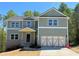 Charming two-story home featuring a light green exterior, gray shutters, and a two-car garage at 66 Pine Creek Ct, Dallas, GA 30157