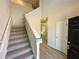 Inviting foyer featuring a staircase with carpeted steps and light-colored wood-look flooring at 66 Pine Creek Ct, Dallas, GA 30157
