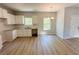 Kitchen featuring white cabinets, countertops, and hardwood floors, plus a window for natural light and an adjacent dining area at 66 Pine Creek Ct, Dallas, GA 30157