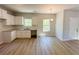 Kitchen featuring white cabinets, countertops, and hardwood floors, plus a window for natural light and an adjacent dining area at 66 Pine Creek Ct, Dallas, GA 30157