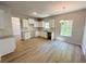 Bright open kitchen with white cabinets, countertops, hardwood floors and natural light from the window at 66 Pine Creek Ct, Dallas, GA 30157