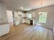 Bright open kitchen with white cabinets, countertops, hardwood floors and natural light from the window at 66 Pine Creek Ct, Dallas, GA 30157