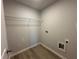 A compact laundry room with wood-look vinyl flooring and utility connections at 66 Pine Creek Ct, Dallas, GA 30157