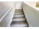 A carpeted stairway is trimmed in white, leading to the upper floors of the residence at 66 Pine Creek Ct, Dallas, GA 30157