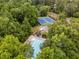 Aerial view of community pool and tennis courts surrounded by lush, mature trees at 1981 Sumter Ct, Lawrenceville, GA 30044
