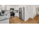 Kitchen with stainless steel appliances, white cabinets, granite countertops and light wood-look floors at 1981 Sumter Ct, Lawrenceville, GA 30044