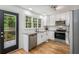 Modern kitchen with stainless steel appliances, granite countertops, and white cabinets, next to a door that leads to an outdoor deck at 1981 Sumter Ct, Lawrenceville, GA 30044