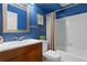 Bathroom with blue walls, wood vanity, and white shower-tub with neutral shower curtain at 2210 Chrysler Ne Ter, Atlanta, GA 30345