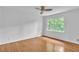 Bright bedroom featuring hardwood floors, ceiling fan, and a window offering backyard views at 2210 Chrysler Ne Ter, Atlanta, GA 30345