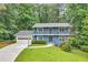Charming two-story blue home featuring a spacious front yard and a two-car garage at 2210 Chrysler Ne Ter, Atlanta, GA 30345