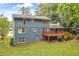 Two-story home with a wooden deck, brick foundation, and fenced in yard surrounded by lush trees at 2210 Chrysler Ne Ter, Atlanta, GA 30345