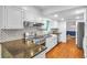 Stylish kitchen featuring stainless steel appliances, granite countertops, white cabinets, and hardwood floors at 2210 Chrysler Ne Ter, Atlanta, GA 30345