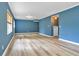 An open living space boasts light wood floors, blue walls, and natural lighting from the window at 2210 Chrysler Ne Ter, Atlanta, GA 30345