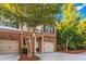 Two-story townhome with a brick facade, attached garage, and small front porch at 2735 Sudbury Trce, Norcross, GA 30071