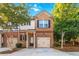 Two-story townhome with a brick facade, attached garage, and small front porch at 2735 Sudbury Trce, Norcross, GA 30071