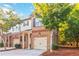 Two-story townhome with a brick facade, attached garage, and a quaint front porch at 2735 Sudbury Trce, Norcross, GA 30071