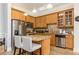Open concept kitchen with wood cabinets, stainless steel appliances, and island with granite countertop at 11 Perimeter E Ctr # 1412, Atlanta, GA 30346