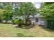 Backyard view of home featuring a small wood deck and lush green trees at 135 Pheasant Se Dr, Marietta, GA 30067