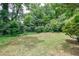 Wide view of a backyard with grass and lush green trees at 135 Pheasant Se Dr, Marietta, GA 30067