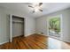 Cozy bedroom features hardwood floors, a ceiling fan, closet, and bright window at 135 Pheasant Se Dr, Marietta, GA 30067